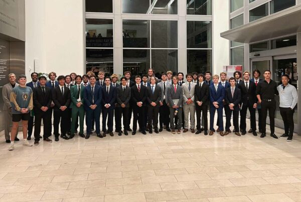 Group of collegians in suits pose for a group photo