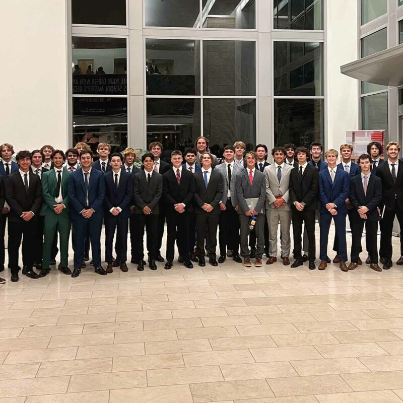 Group of collegians in suits pose for a group photo