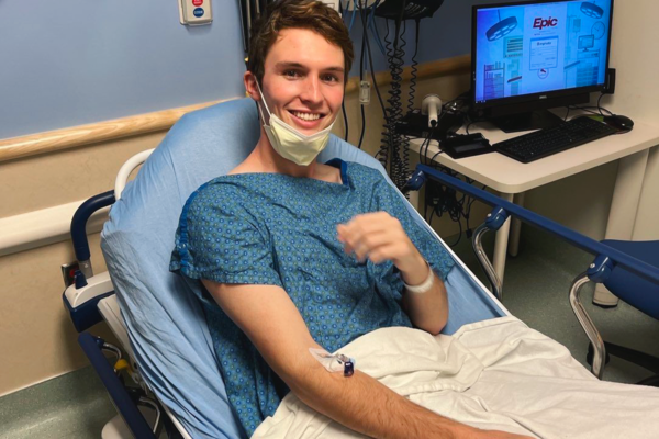 Luke Karel, Kansas '26, sits in a hospital bed in preparation of his chemotherapy treatment.