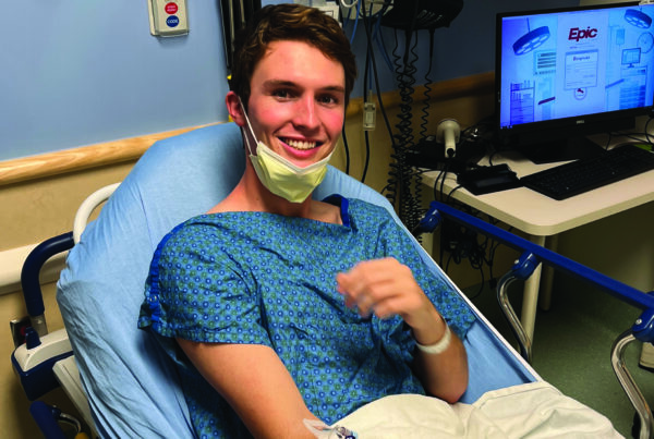 Luke Karel, Kansas '26, sits in a hospital bed in preparation of his chemotherapy treatment.
