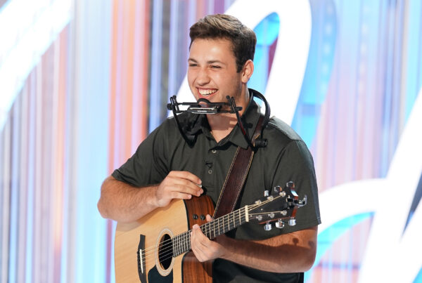 Owen Eckhardt, Oklahoma State '26, smiles while holding his guitar on set after his American Idol audition.